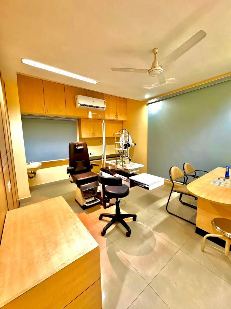 Caring Vision Therapy Anna Nagar Chennai - Consultation room with patient examination chair, slit lamp and doctor's desk