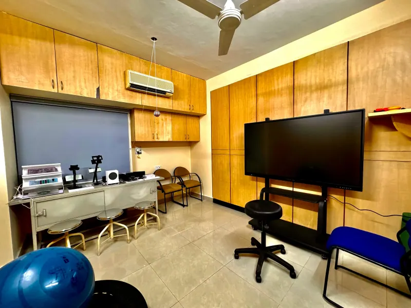 Caring Vision Therapy Anna Nagar Chennai - Vision therapy room with optical instruments, large interactive display screen and therapy equipment