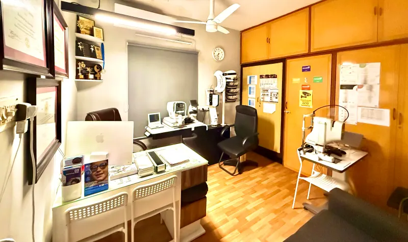 Caring Vision Therapy Ashok Nagar Chennai - Consultation room with iMac workstation, auto-refractor and multiple diagnostic instruments