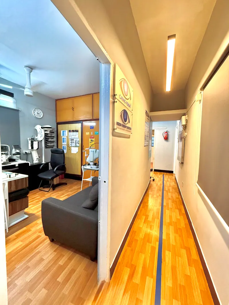 Caring Vision Therapy Ashok Nagar Chennai - Clinic corridor with diagnostic room entrance and Caring Vision logo signage