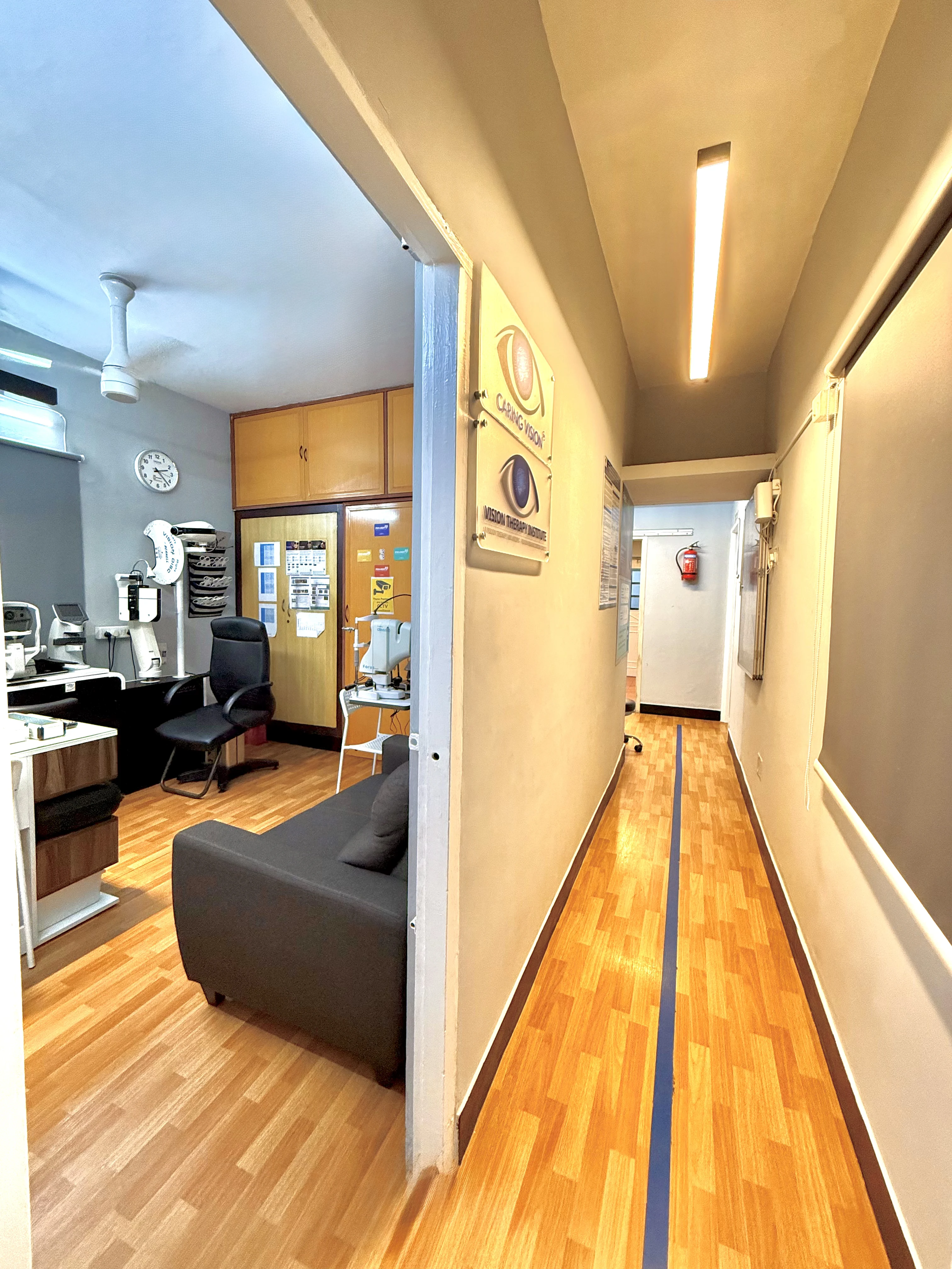 Caring Vision Therapy Ashok Nagar Chennai – Clinic corridor with diagnostic room entrance and Caring Vision logo signage