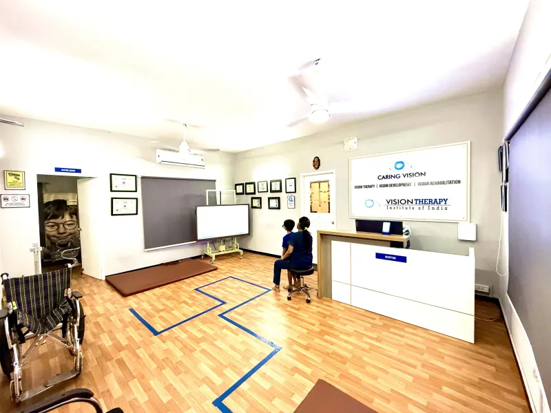 Caring Vision Therapy Ashok Nagar Chennai - Main clinic floor showing reception counter, interactive display screen and wheelchair-accessible space
