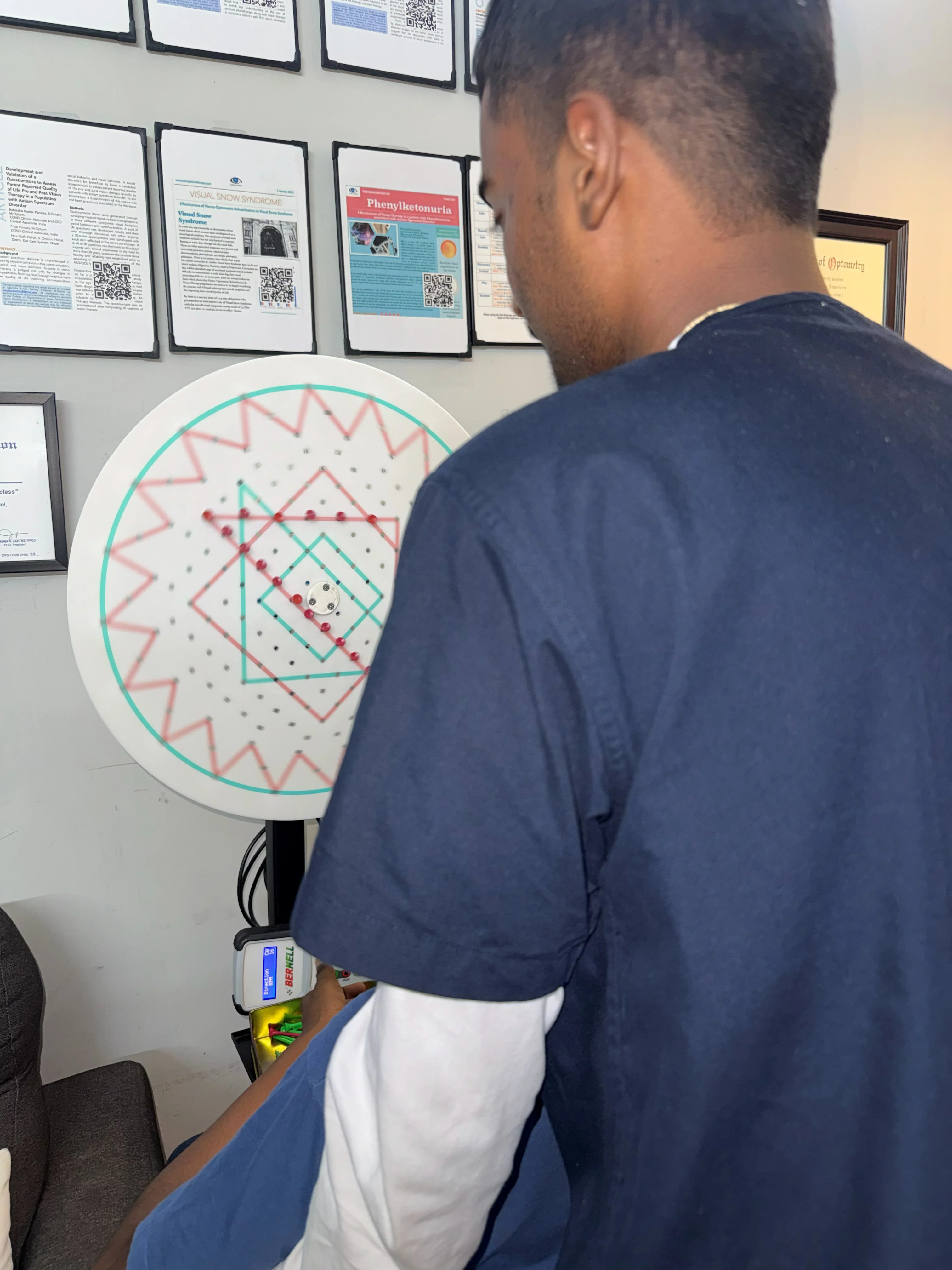 Caring Vision Therapy Ashok Nagar Chennai - Patient performing saccadic eye movement exercise on circular wall chart