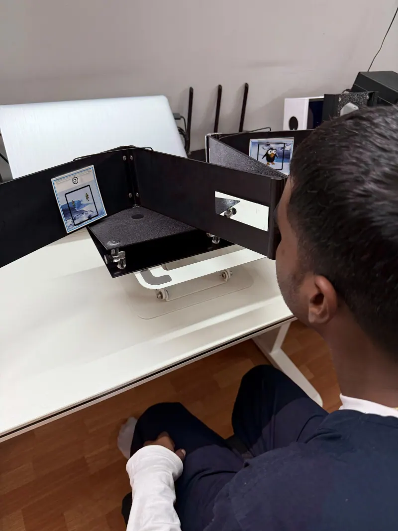 Patient doing a fusion card exercise with a tabletop stereoscope during lazy eye therapy