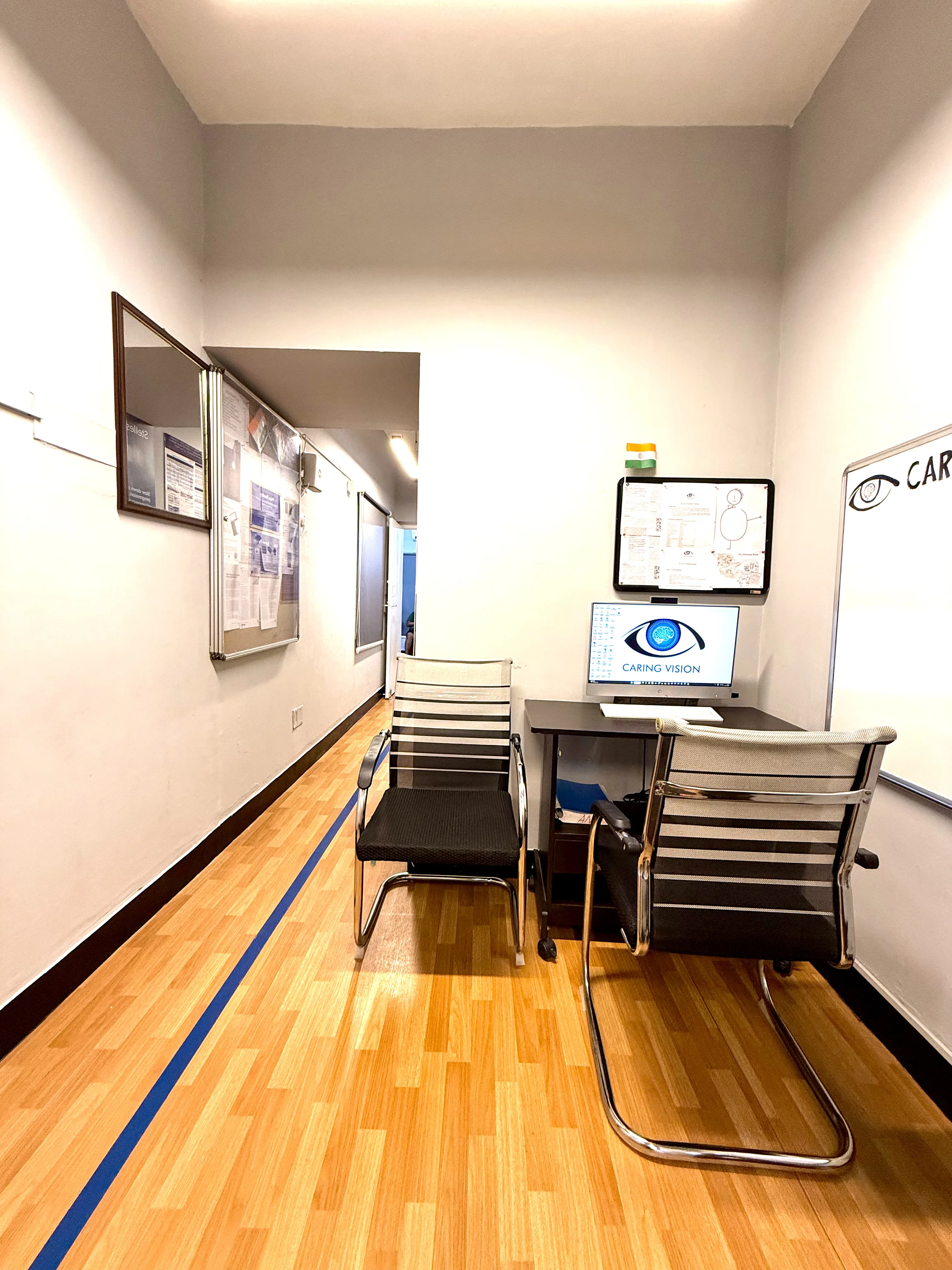 Caring Vision Therapy Ashok Nagar Chennai – Vision assessment workstation with Caring Vision branded monitor and whiteboard