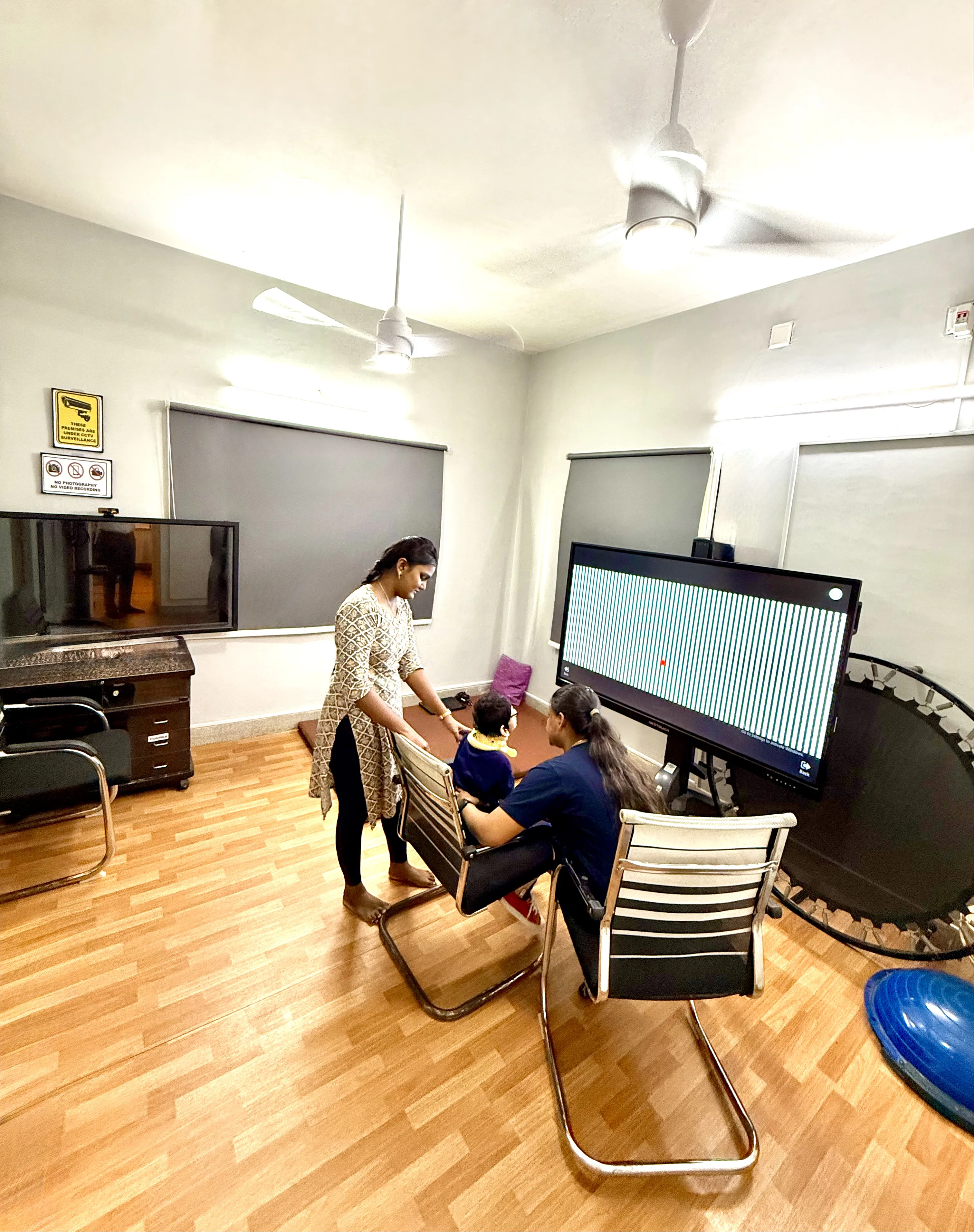 Caring Vision Therapy Ashok Nagar Chennai – Therapist conducting vision therapy session with child patient at interactive display screen