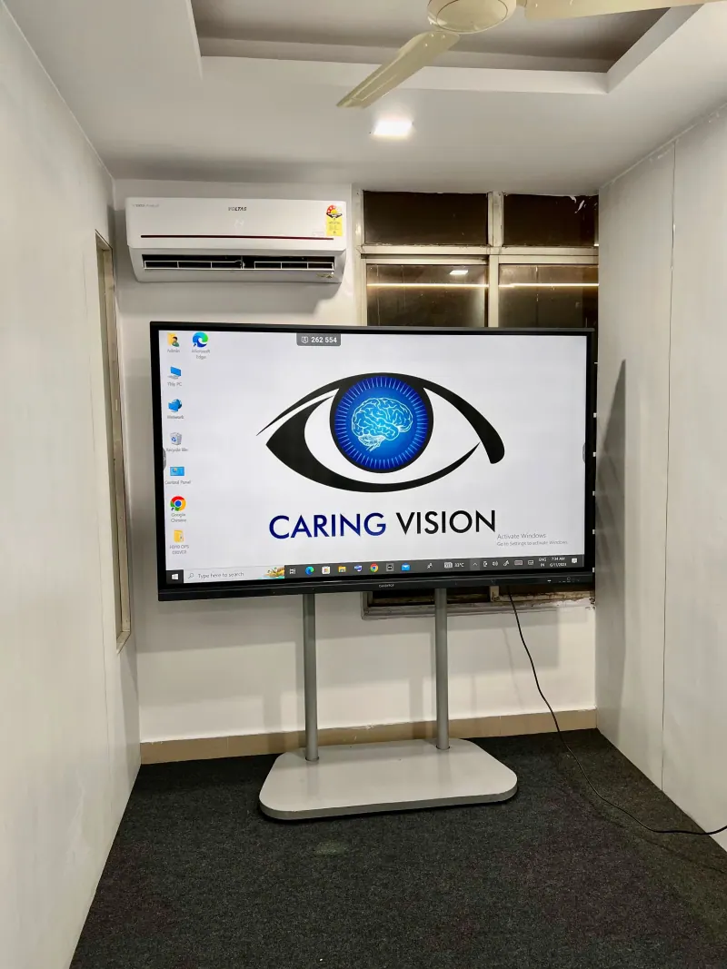 Caring Vision Therapy Hyderabad - Vision therapy room with large Caring Vision branded interactive display screen
