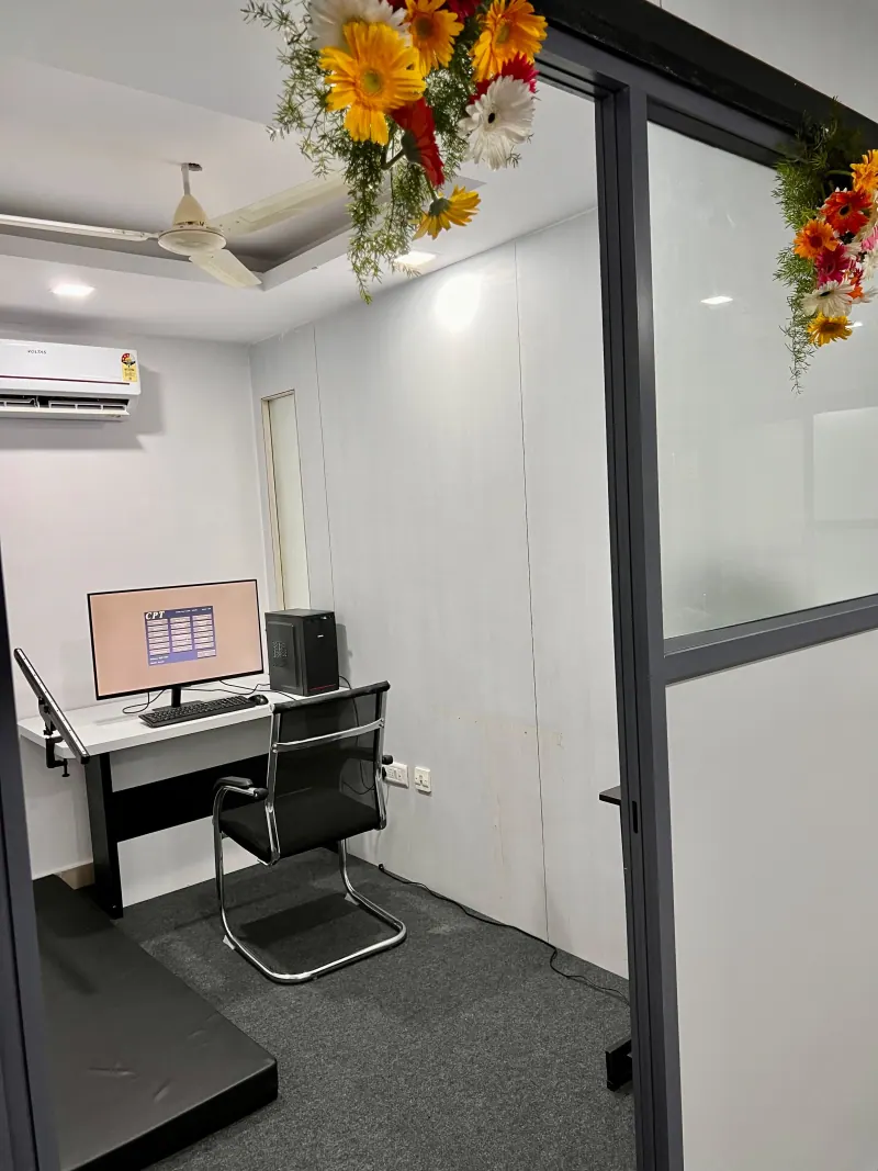 Caring Vision Therapy Hyderabad - Vision therapy room with computer workstation and glass-partitioned private space