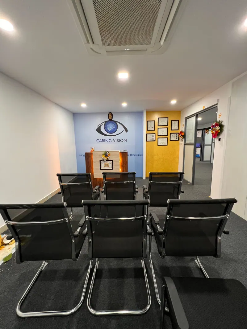 Caring Vision Therapy Hyderabad - Patient waiting area and reception with rows of chairs and branded feature wall