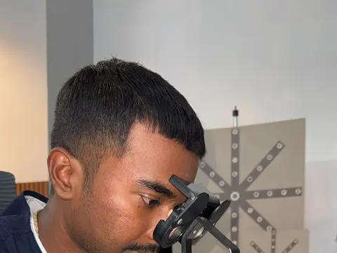 Patient using a binocular vision instrument during lazy eye and squint therapy at Caring Vision Therapy