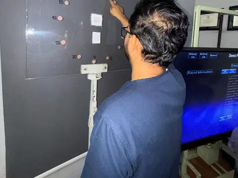 Adult doing a peripheral vision wall exercise during neuro-vision rehabilitation at Caring Vision Therapy